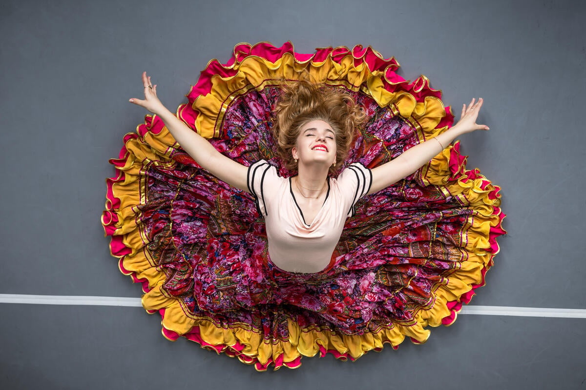 A woman wearing a colorful skirt dances.