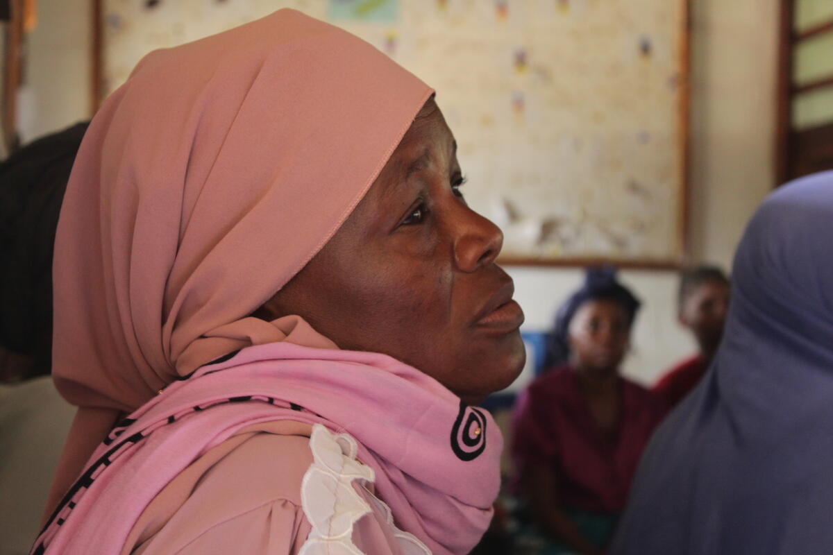 A portrait of a woman wearing a pink headscarf