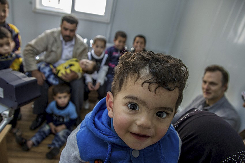 A young boy queues up with his family to be registered at the UNHCR registration offices in Amman, Jordan