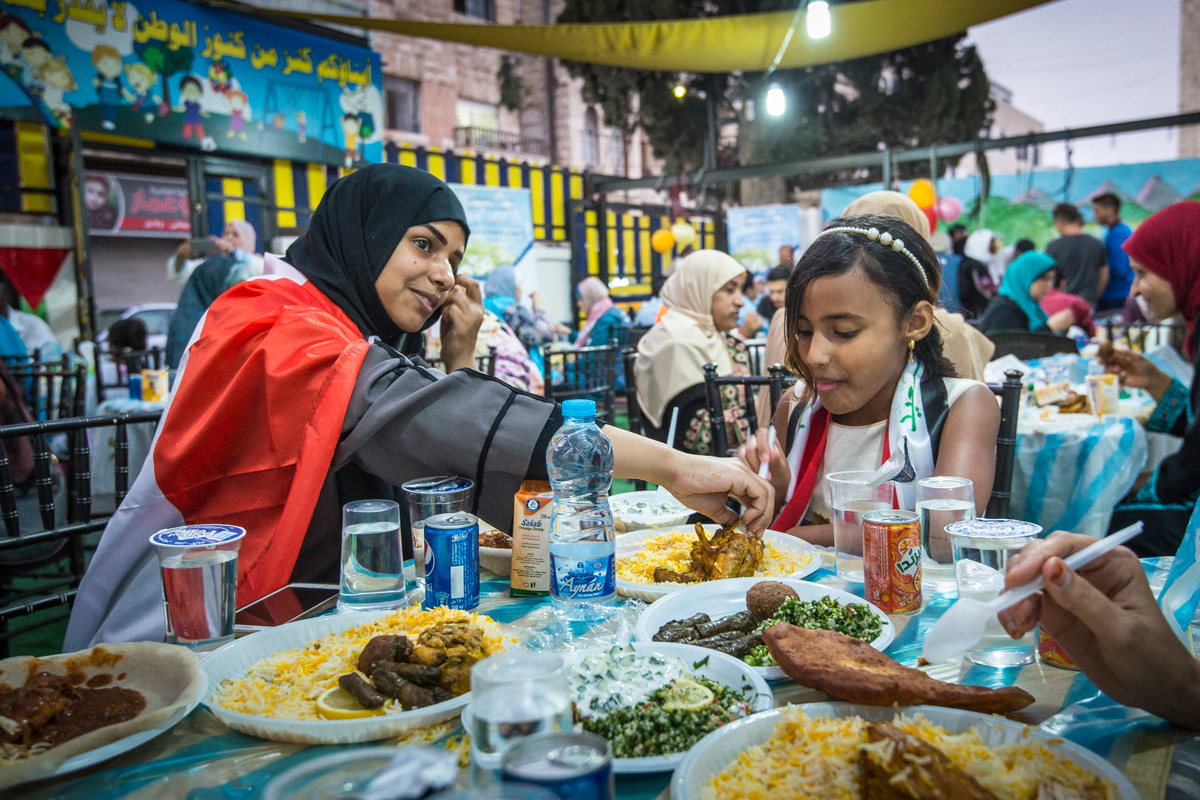 JORDAN. Refugees get together to break the Ramadan fast.