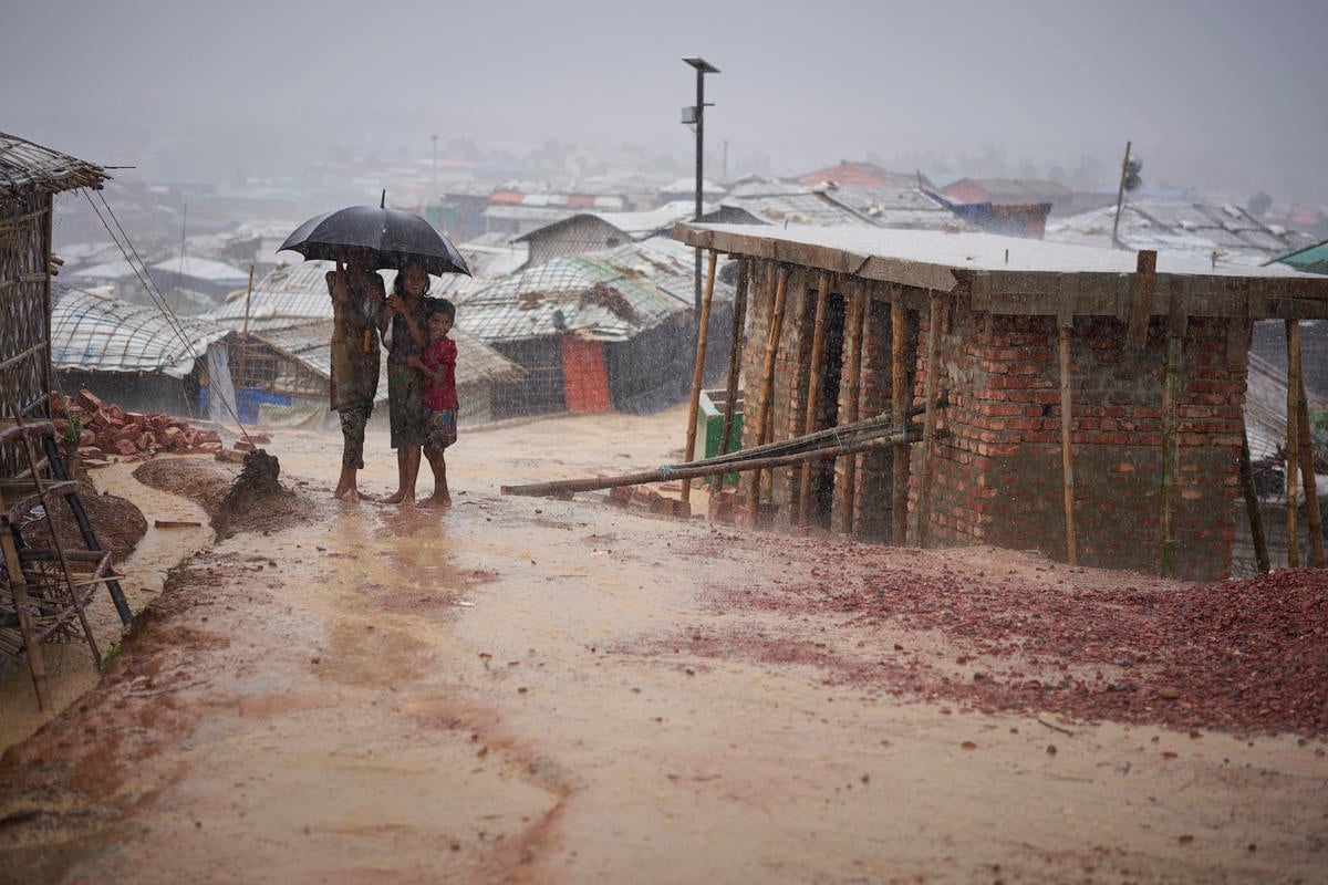 Bangladesh. Rohingya refugees walk through a heavy monsoon downpour