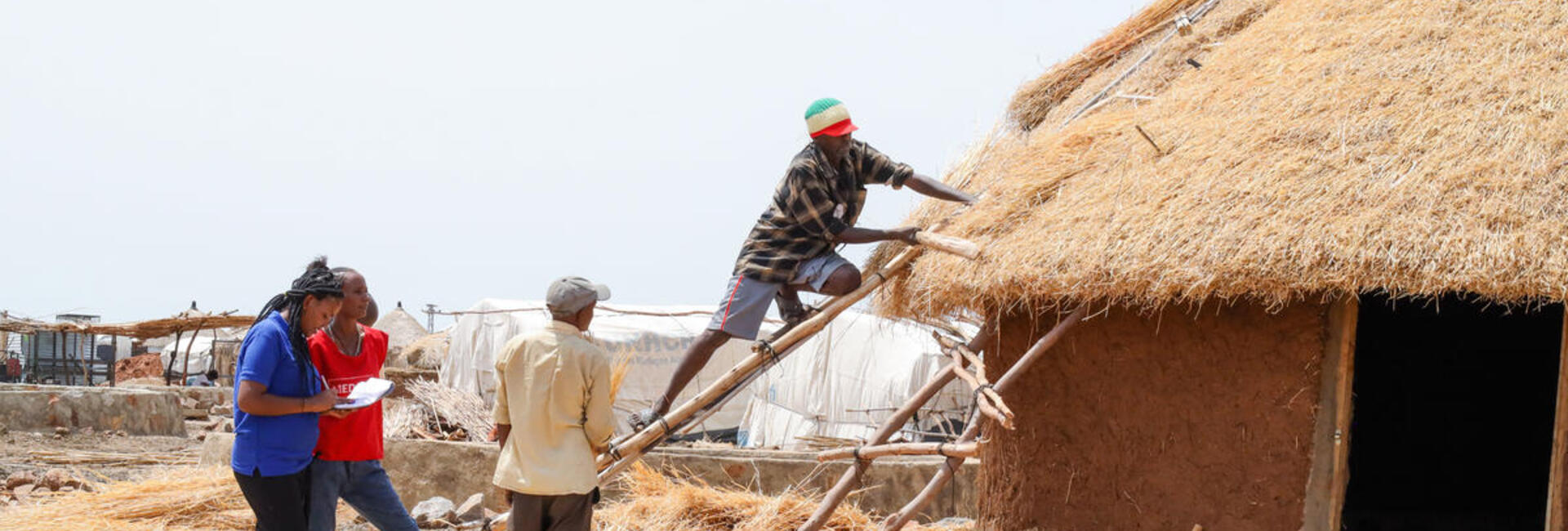 Sudan. Refugee civil engineers supervise shelter construction