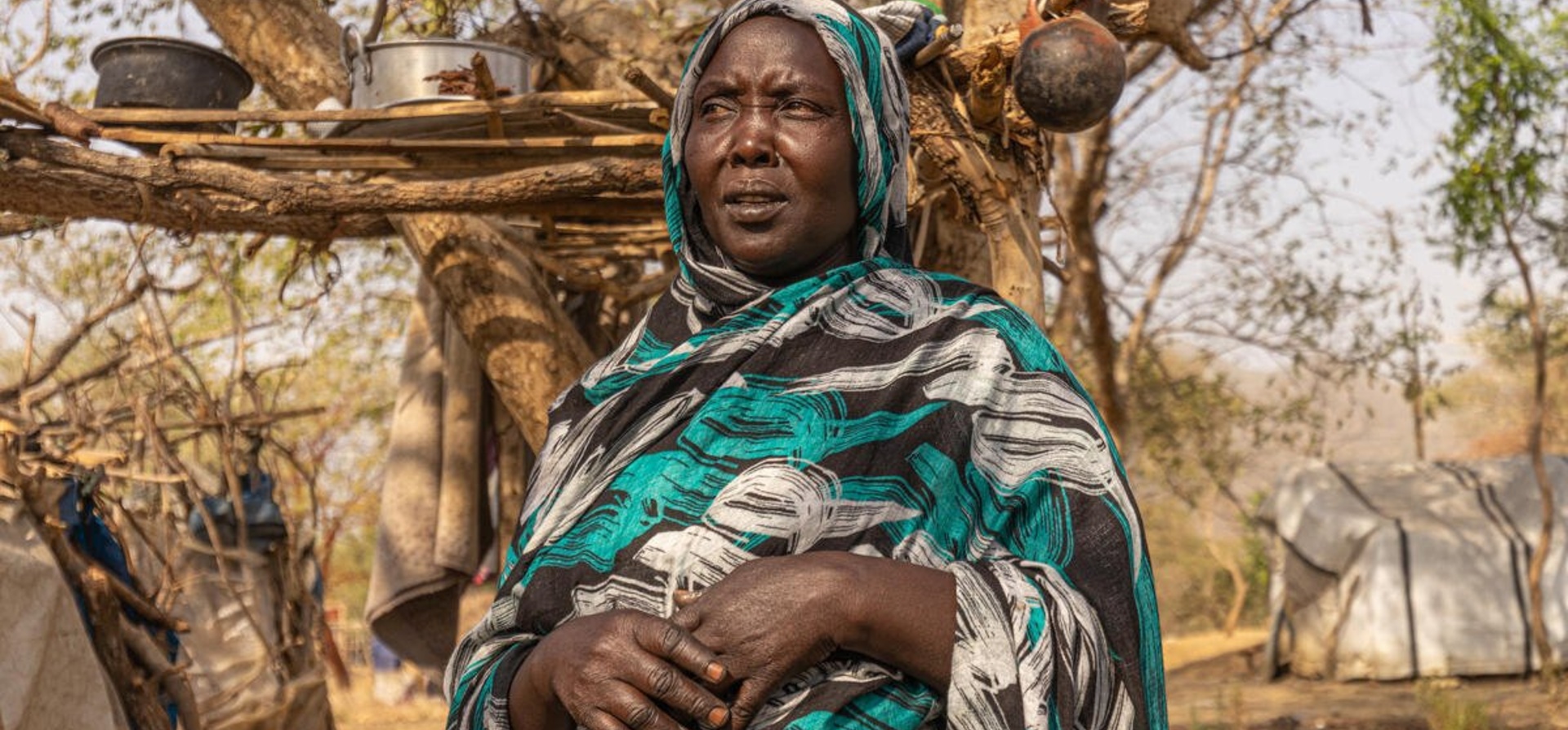 A Sudanese woman in front of a shelter