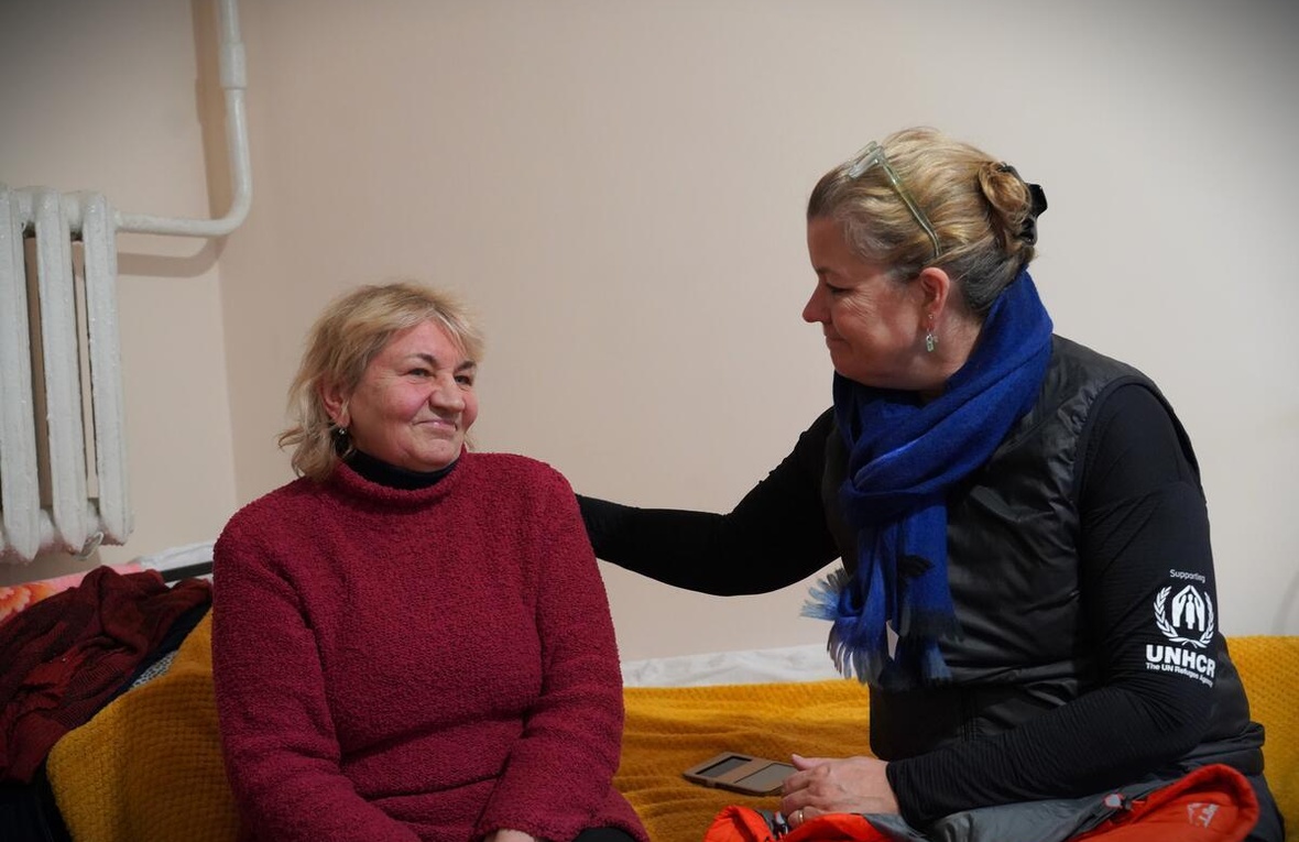 Two women sit together, talking
