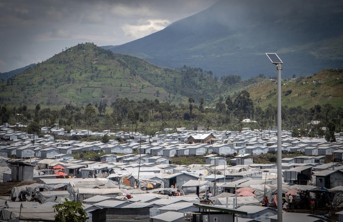 A displacement site surrounded by mountains on a cloudy day.