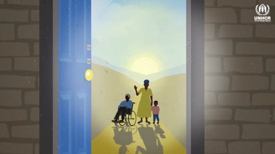 A woman waving, holding a child by the hand, and standing next to a man in a wheelchair.
