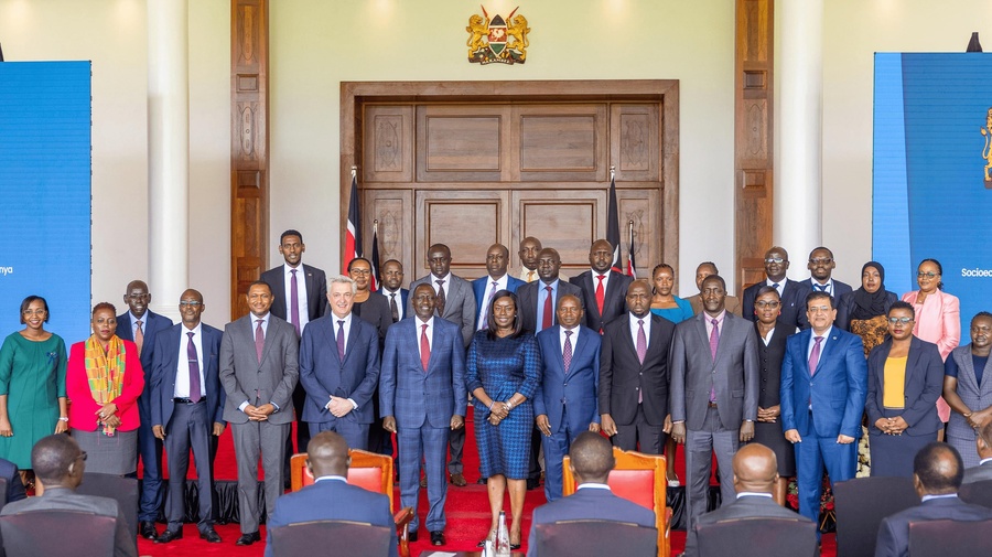 A group of people standing in two rows in front of an audience