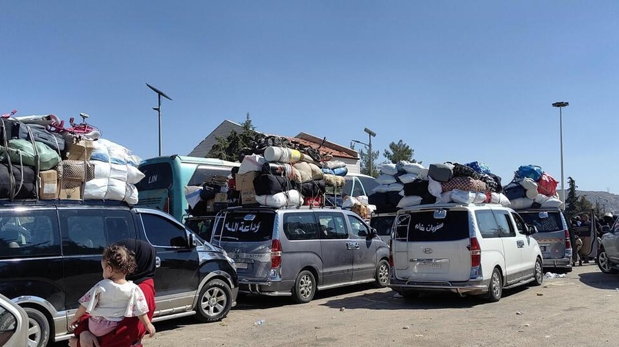 Cars piled with belongings sit in traffic.