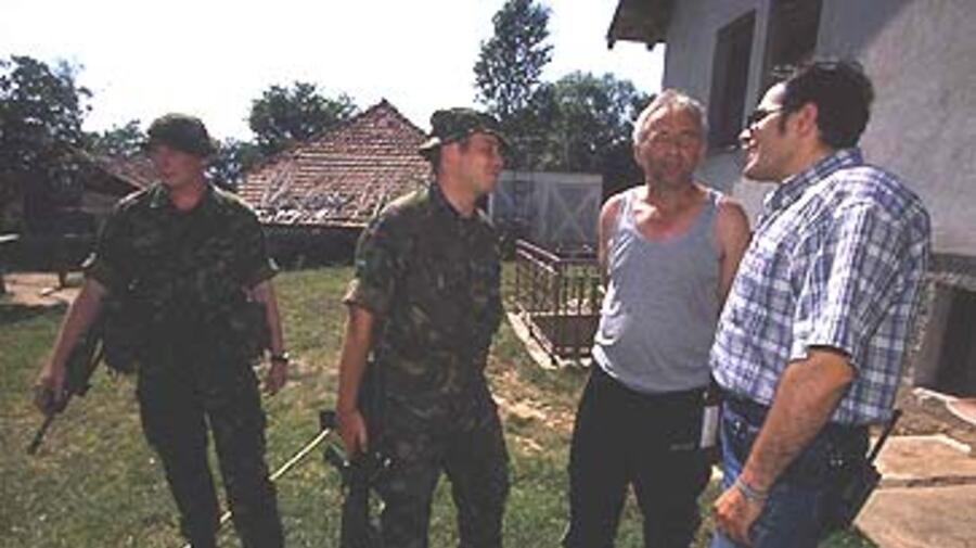 K-FOR and UNHCR staff check on Kosovo Serbs surrounded by ethnic Albanians.