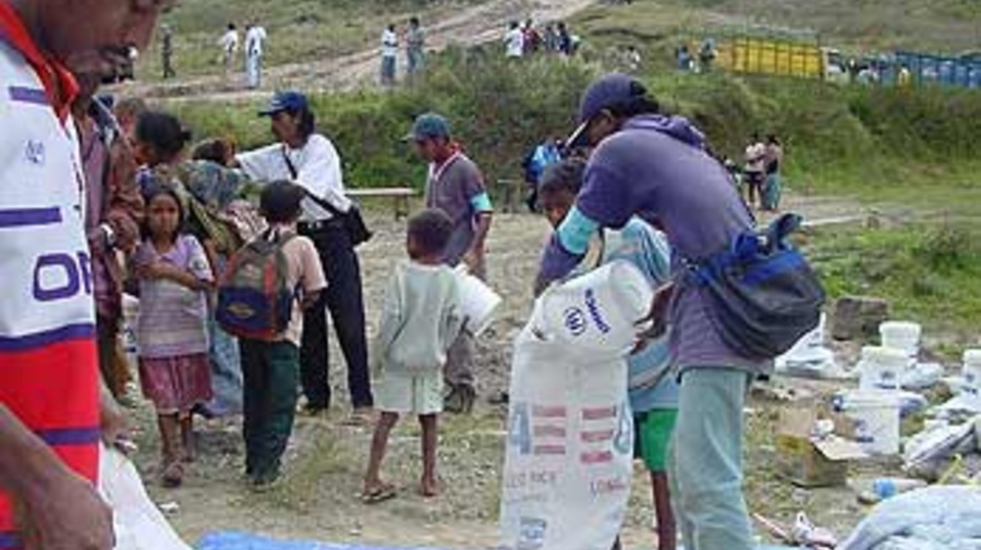 East Timorese refugees receive supplies as they return through the Lakhmaras ridge in East Timor.