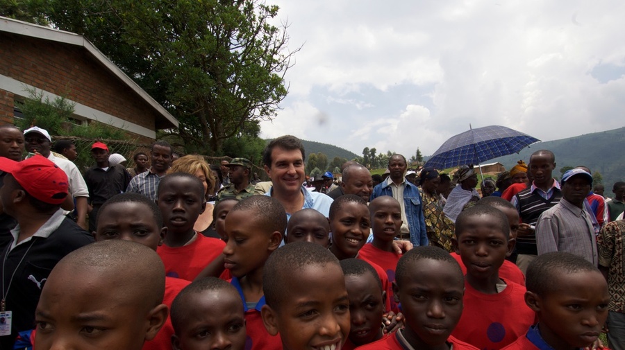 FC Barcelona President Joan Laporta surrounded by excited children at Kiziba camp.