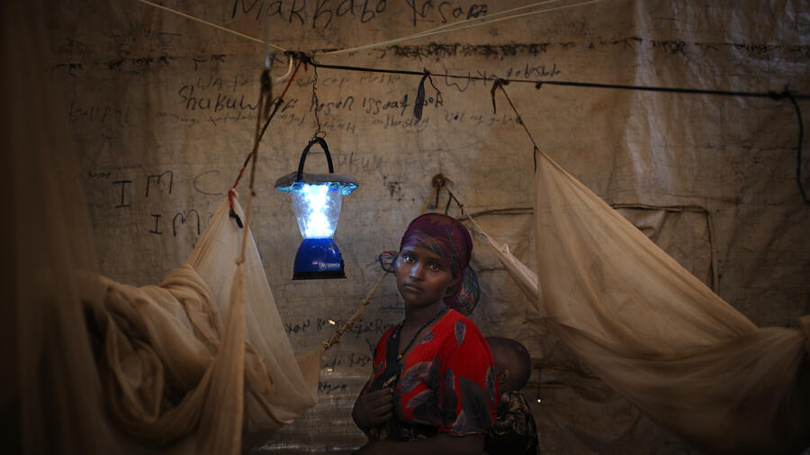A solar-powered lantern helps this Somali mother and her child in their shelter eastern Ethiopia's Kobe Refugee Camp