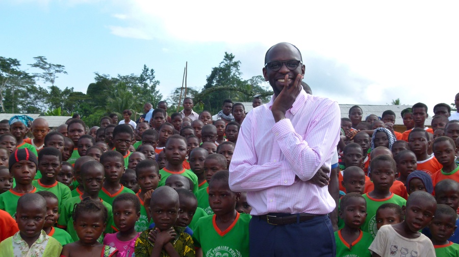 Mohamed Askia Touré, UNHCR's representative in Côte d'Ivoire, among a sea of children in an Ivorian village