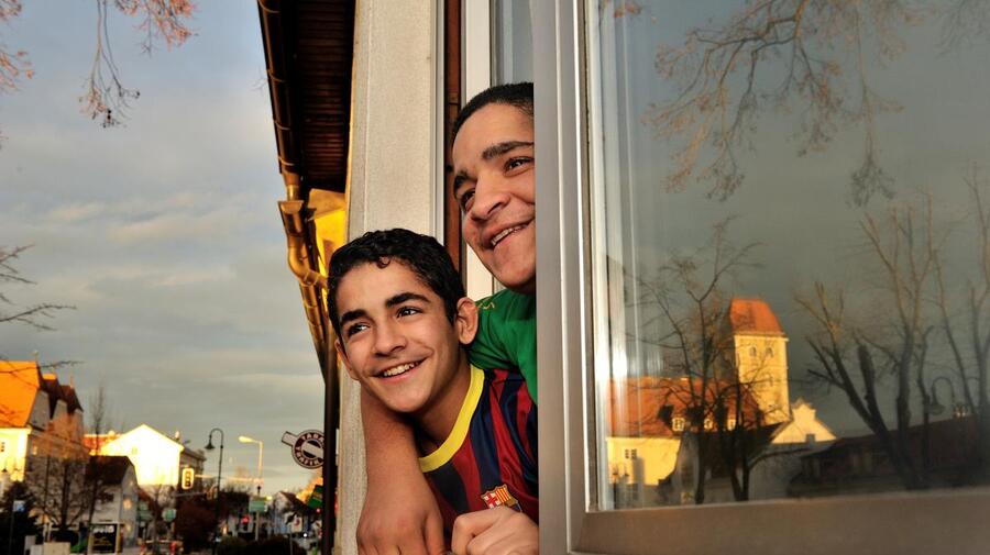 Austria. Syrian refugee kids looking out from their new home in a small town. They are on a resettlement program for Syrian refugees, in cooperation with UNHCR