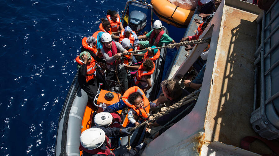 Crew from a Sea Watch search and rescue vessel rescue survivors from a boat that foundered trying to cross the Mediterranean to Europe from Libya in 2016.