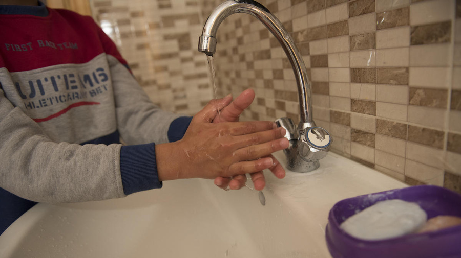 Jordan. Qusai (11) washes his hands in the sink at home