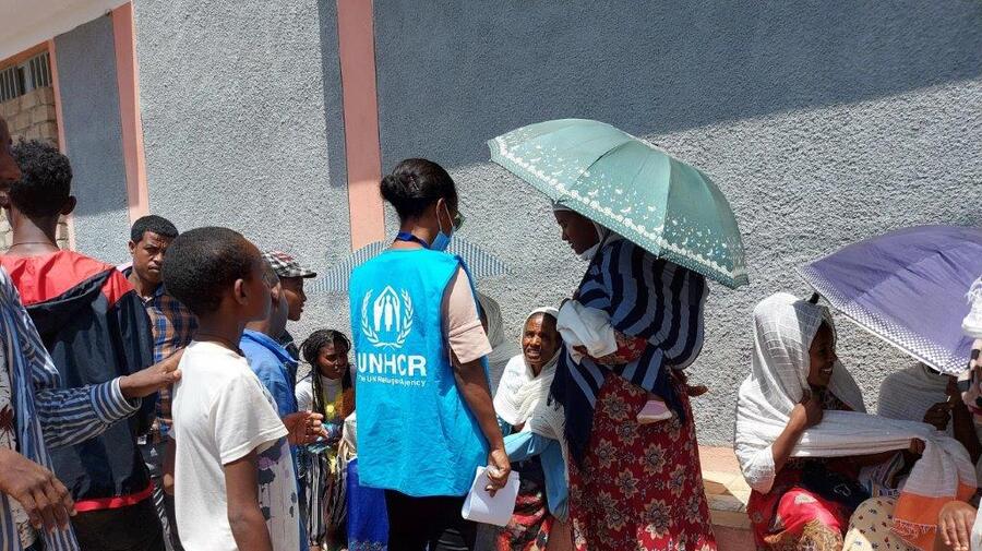 A UNHCR staff member speaks to internally displaced people in the street in Axum, in the Tigray region of Ethiopia. 