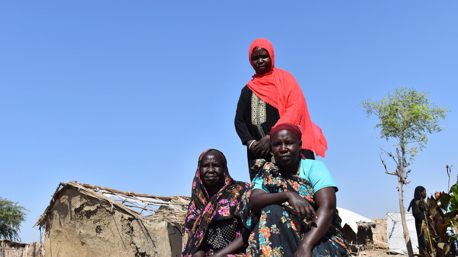 Sudan. Nyalam, Triza and Suzana stand together where the floods devastated many of the shelters in Al Redis 1 refugee camp