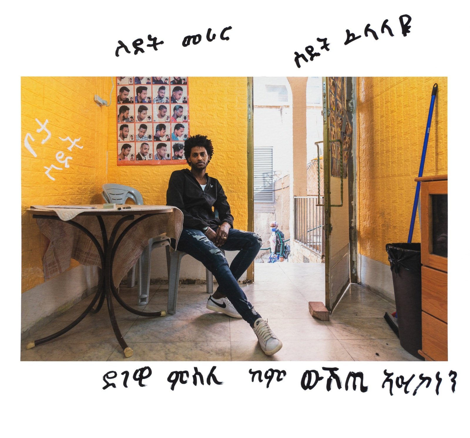 אנדום, מבקש מקלט מאריתריאה, יושב במספרה שלו ליד שוק תלפיות בחיפה, 12 באפריל 2021.