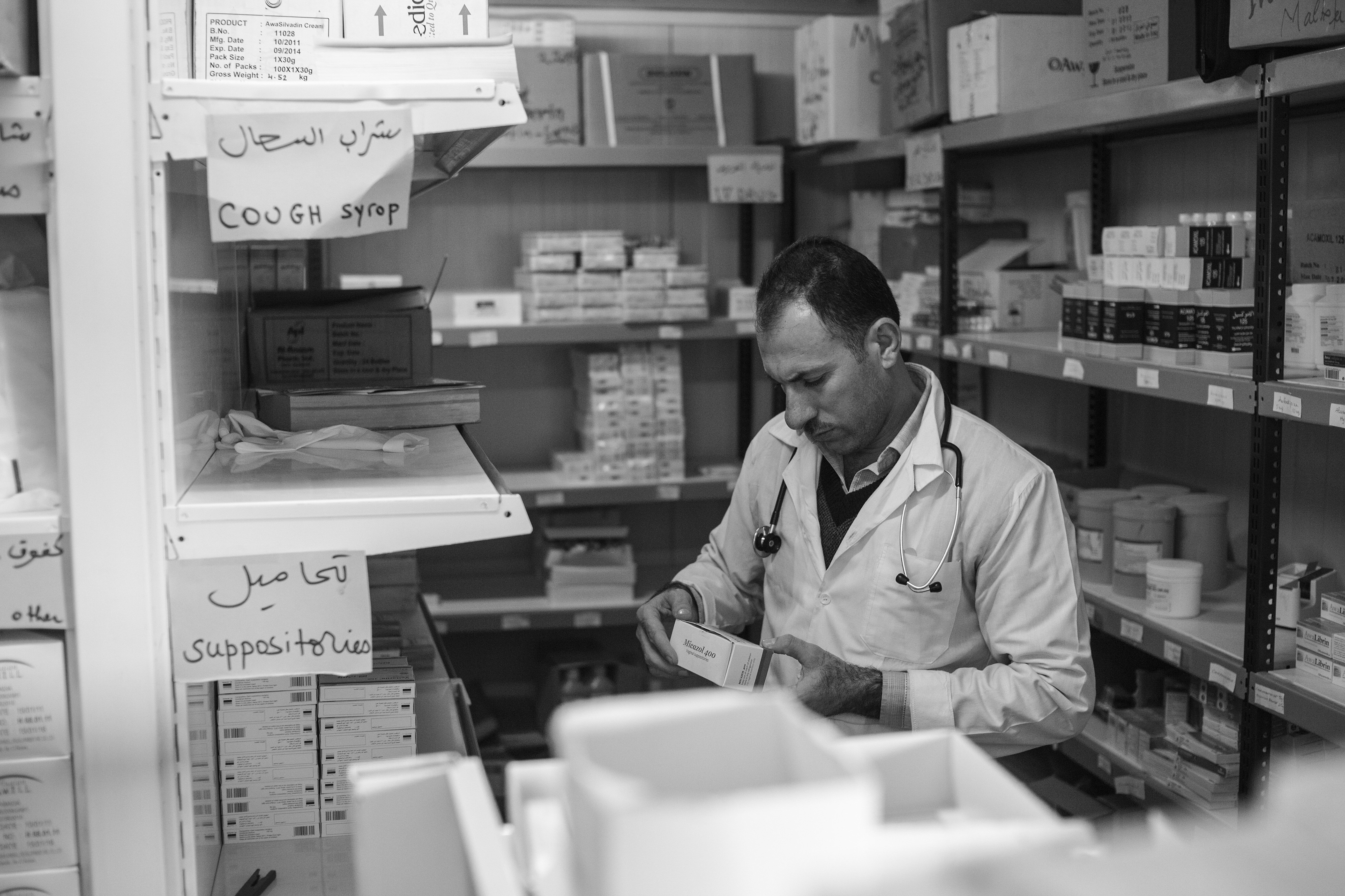 Dr. Hassan checks a box of medicine in the pharmacy of the Médecins Sans Frontières clinic in Domiz Refugee Camp