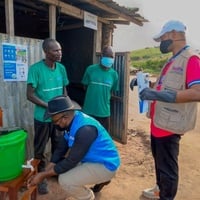 UNHCR staff inspect a chlorinated handwashing station