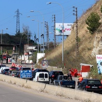 A line of cars waits to cross a checkpoint 