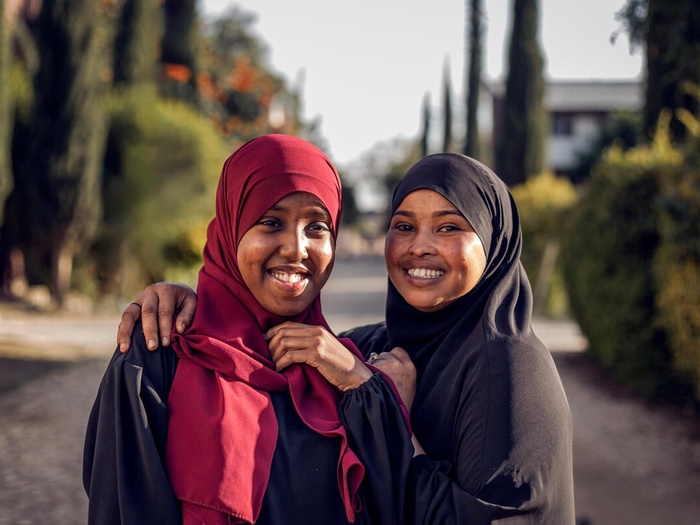 Two young women smile at the camera.
