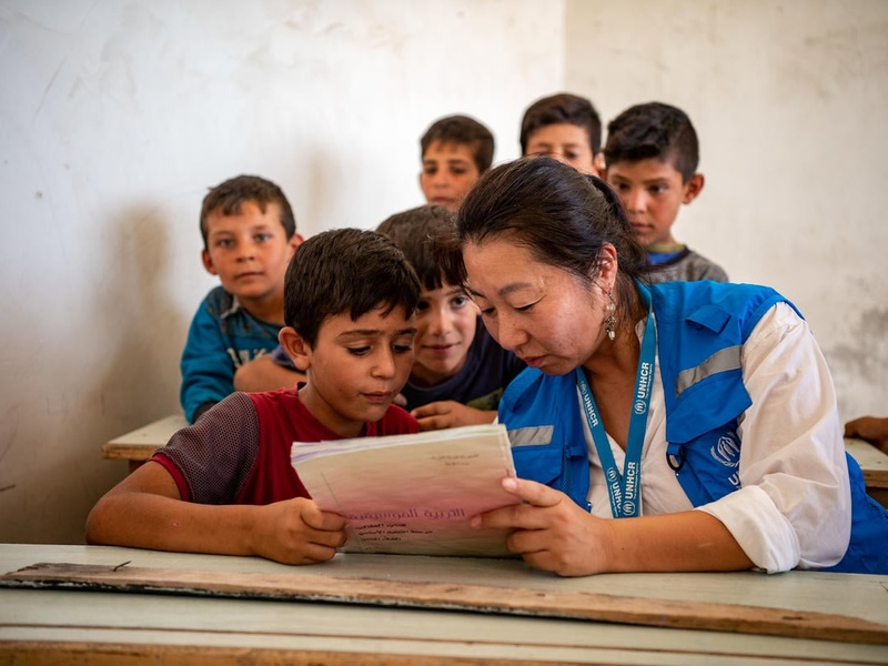 A UNHCR staff member reads a book with a child, in Aleppo, Syria.