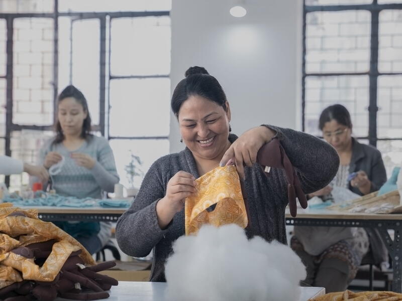 An Afghan refugee woman living in India working at her station.
