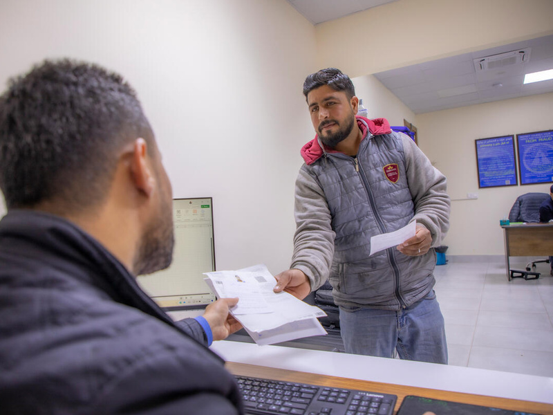 A Syrian refugee living in Iraq receives official documents from a UNHCR staff member.