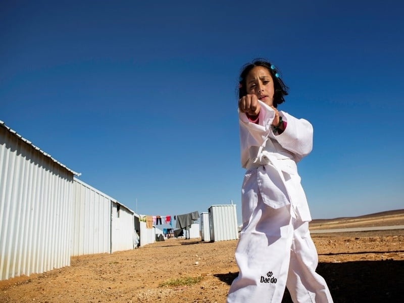 A young girl practices karate moves.