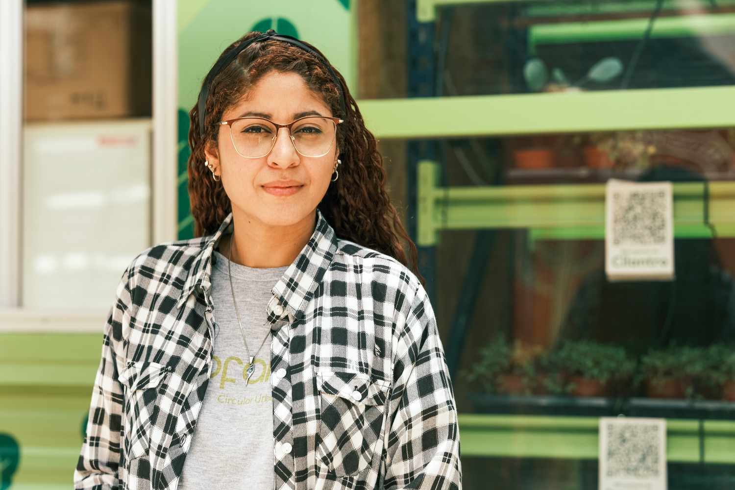 Abelis looks at the camera, in front of a window full of microgreens