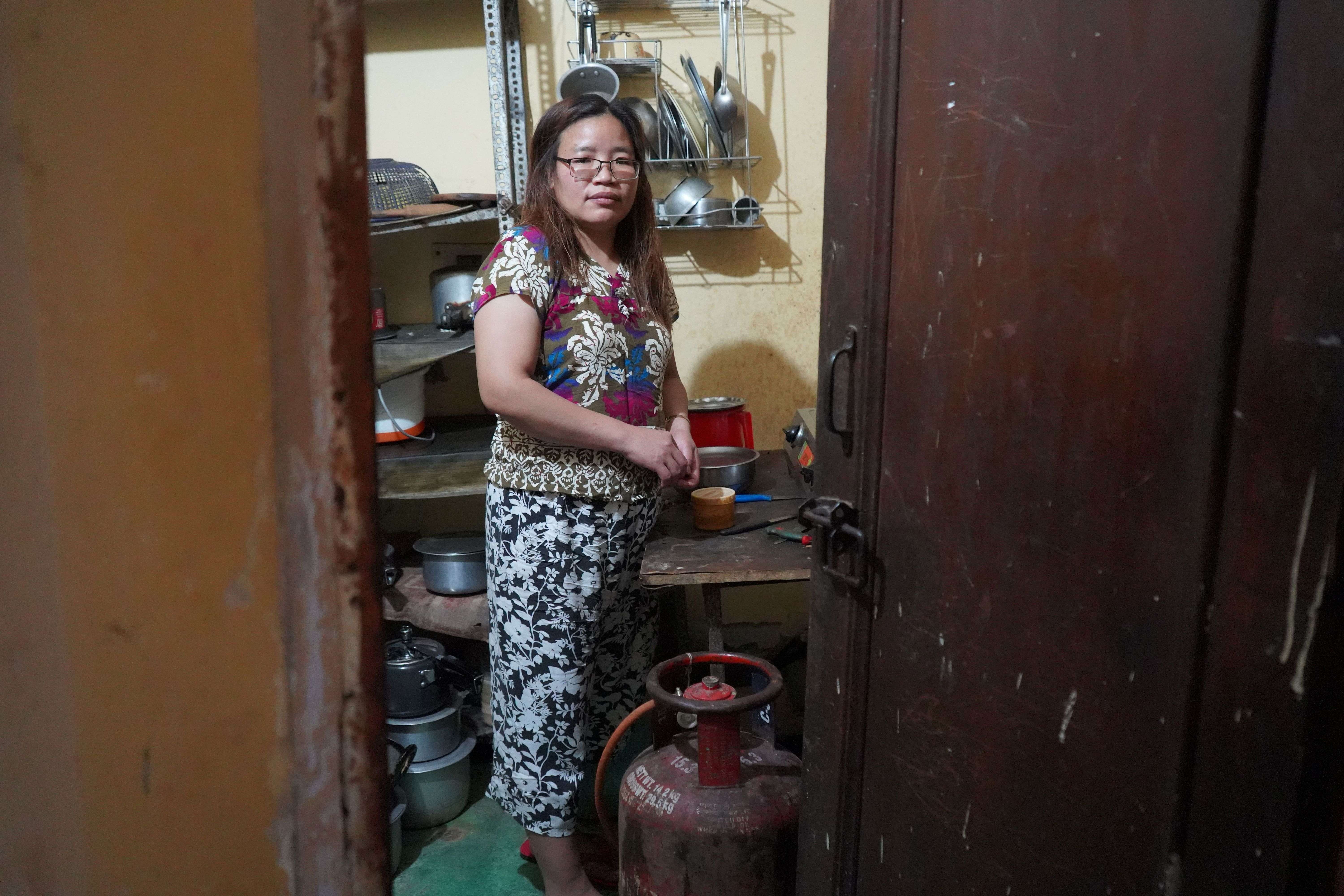 Chin refugee Lian stands in her shared kitchen in Delhi, where soaring cooking gas prices have turned everyday cooking into a daily struggle for survival.