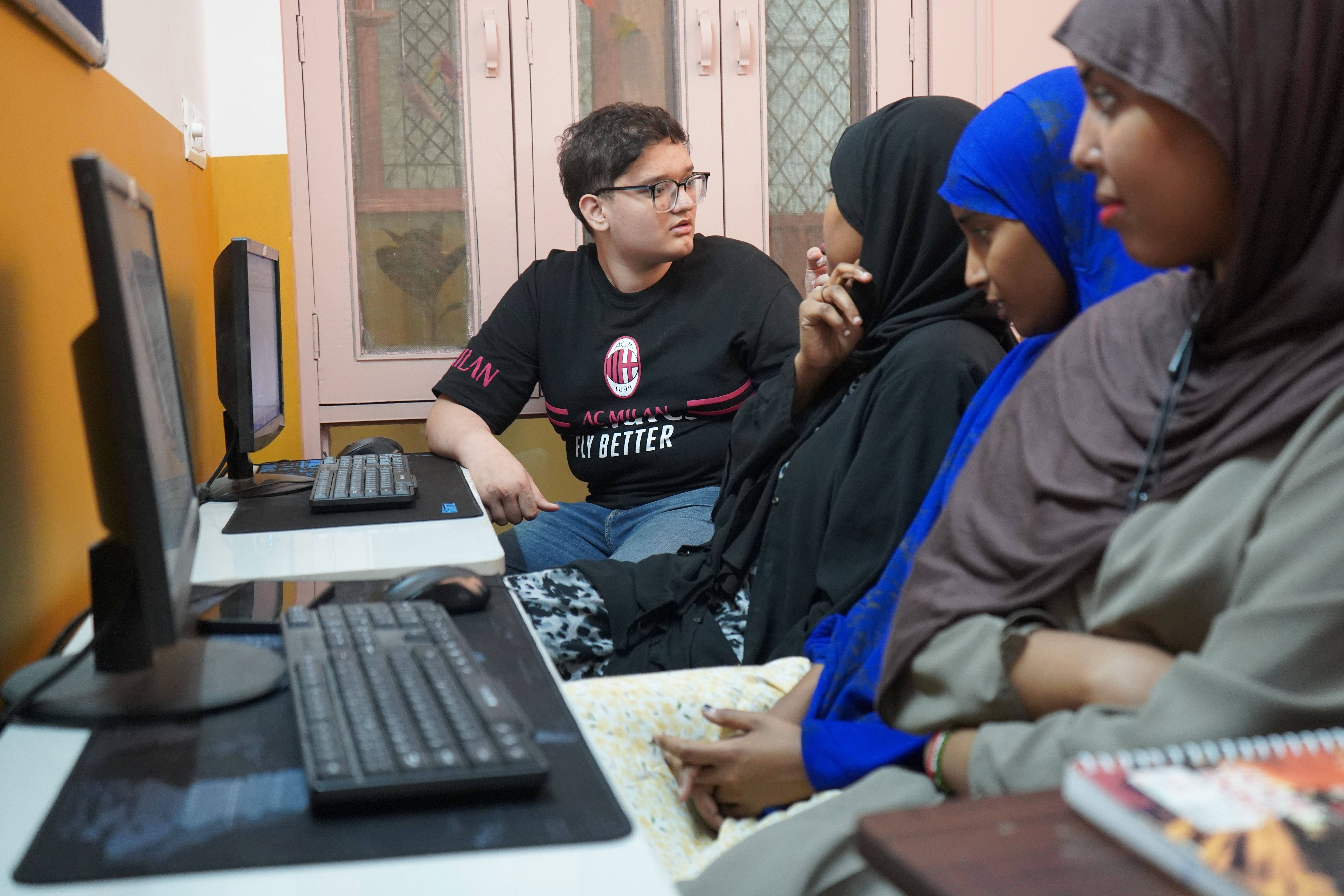 Farid, an Afghan refugee and student of graphic design, teaches computer skills while pursuing his own education.