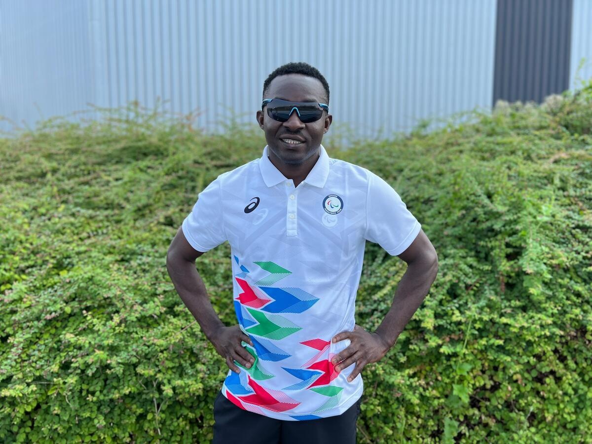 Guillaume Junior Atangan, wearing dark sunglasses, poses for a photo at a training camp in Reims, France