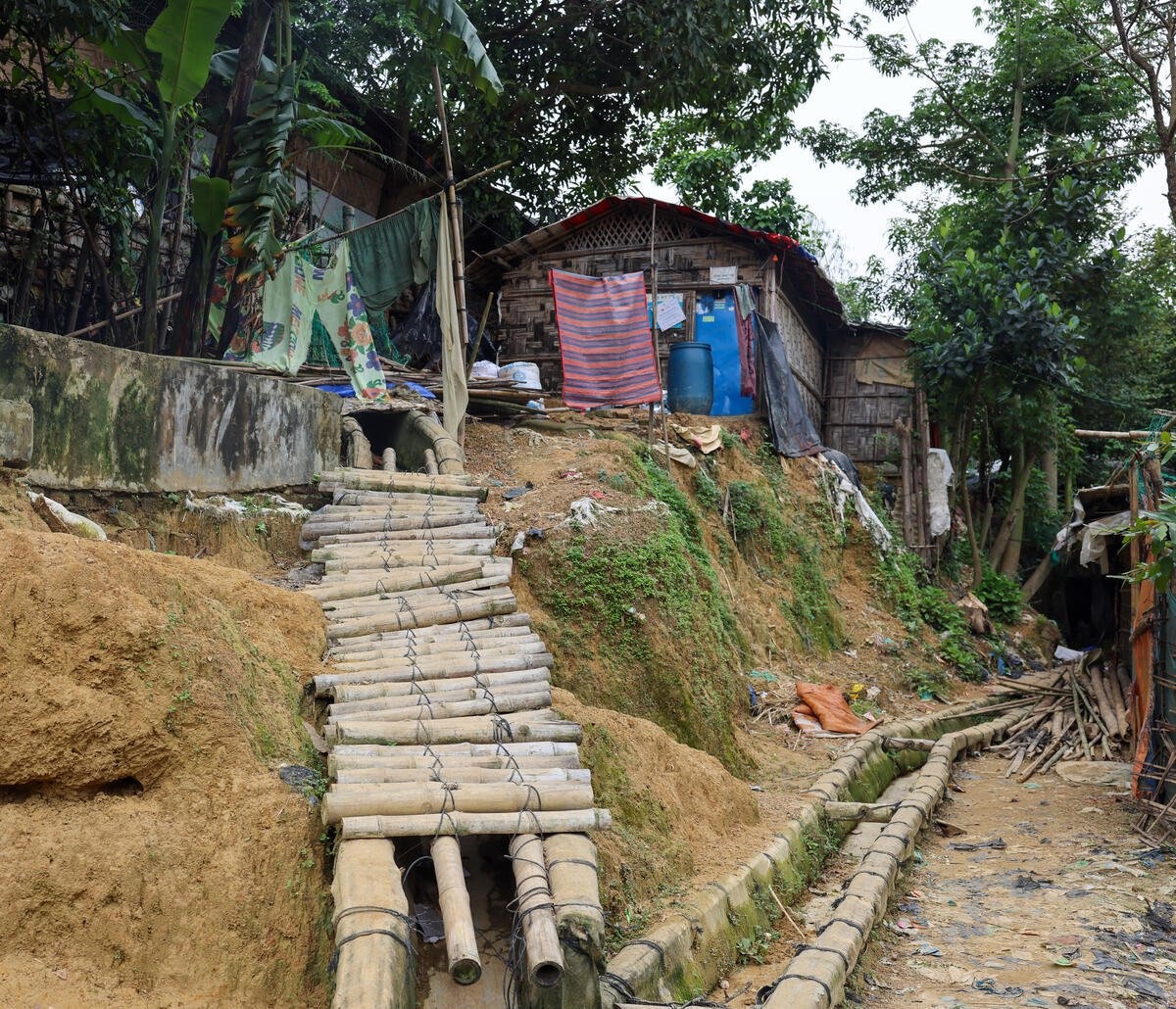 An uneven bamboo path on a hillside in a camp that has been eroded by monsoon rains.