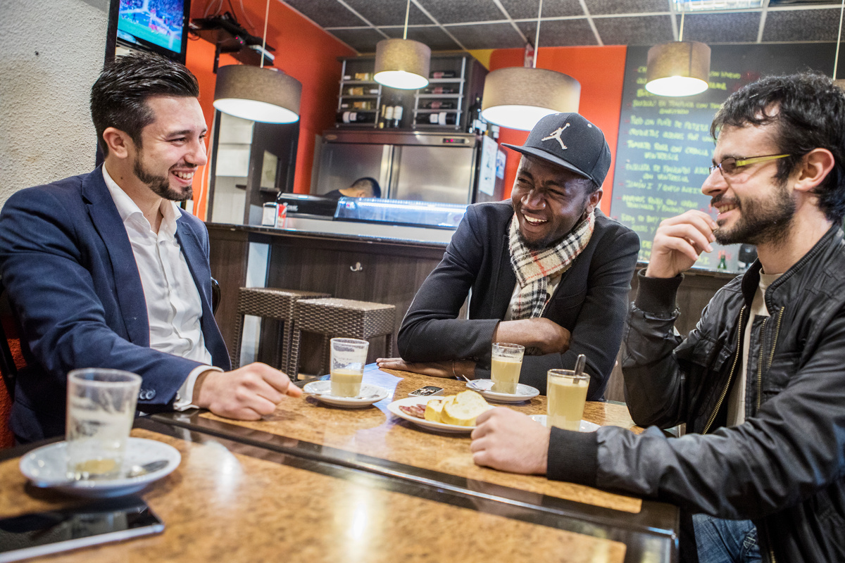 Spain. Asyum seeker and his two Spanish mentors meet for drinks