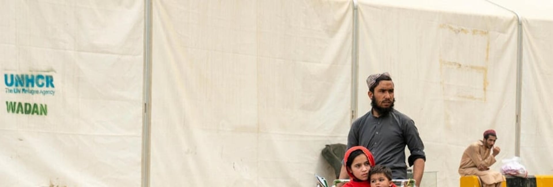 Hadigul porte ses jeunes sœurs, Sabria et Freshta, alors qu’ils voyagent ensemble après leur récent retour en Afghanistan. Malgré les épreuves qu’ils ont traversées, cette famille très unie fait preuve de résilience et de force pour aller de l’avant.