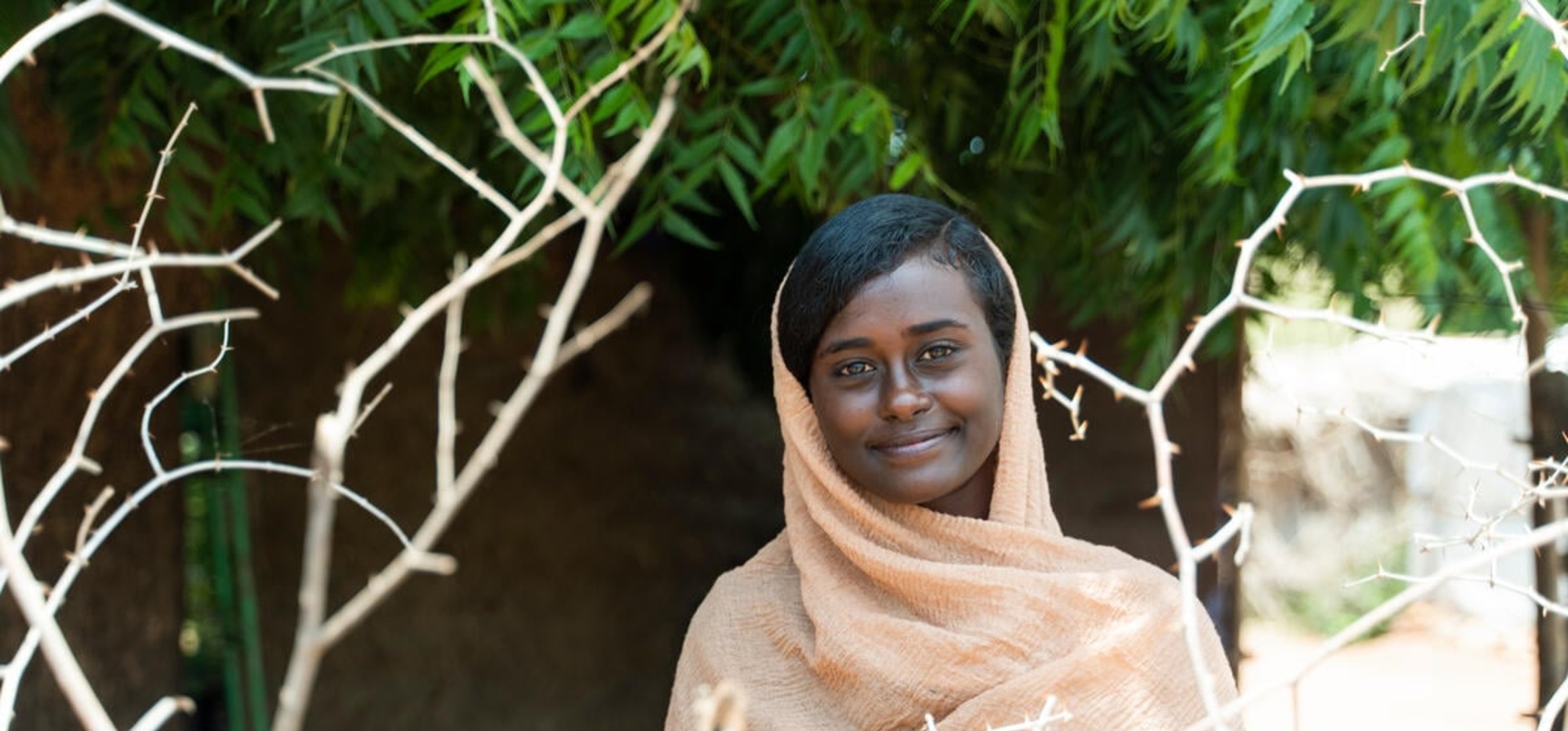 A smiling Sudanese woman, outside