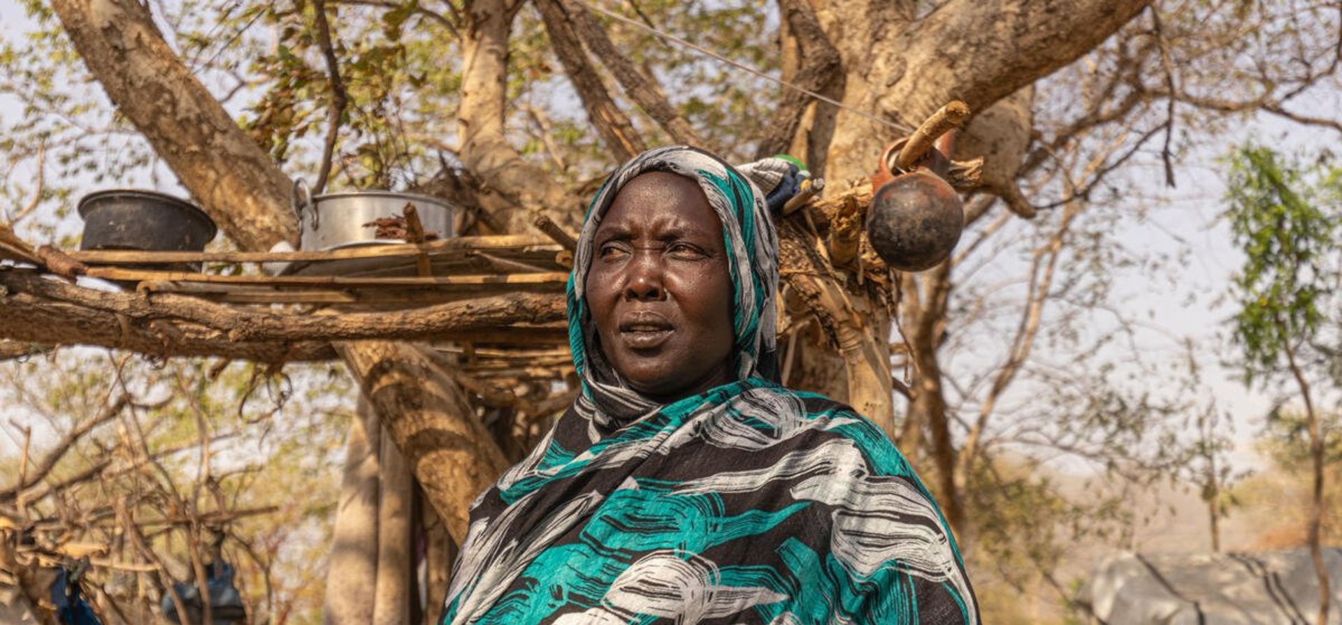 A Sudanese woman in front of a shelter