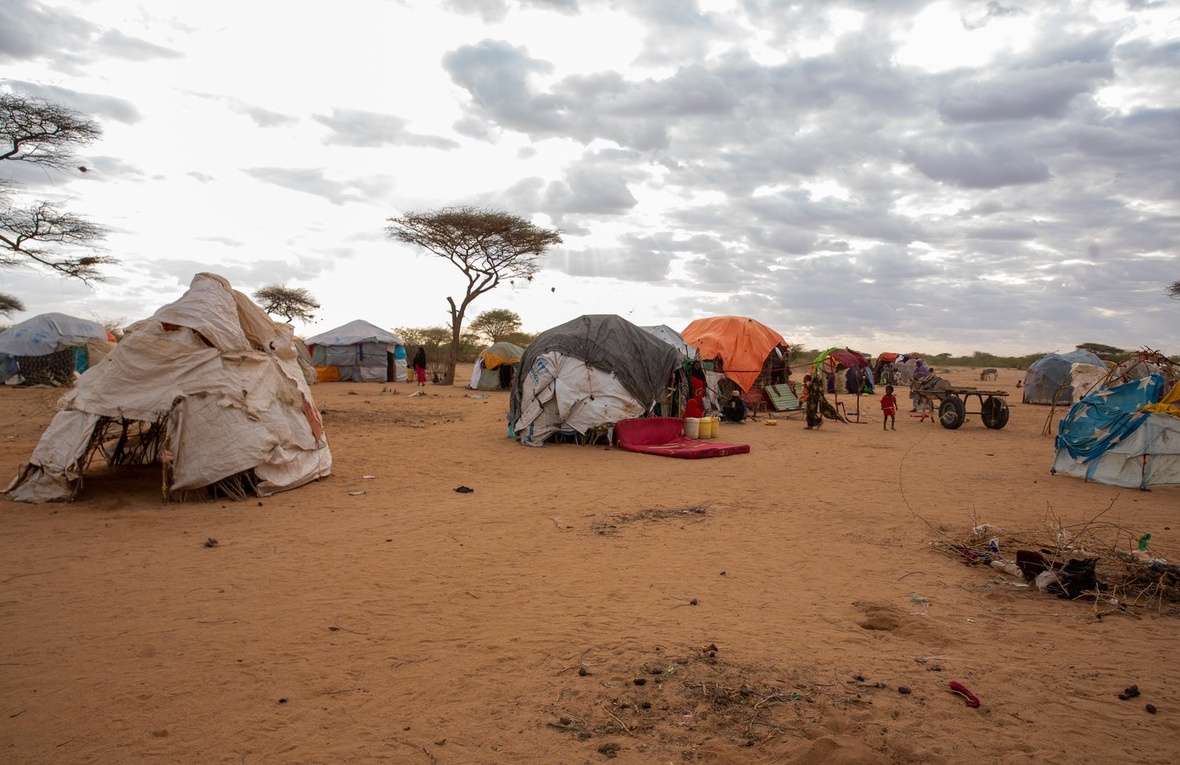 Makeshift shelters in an arid landscape.