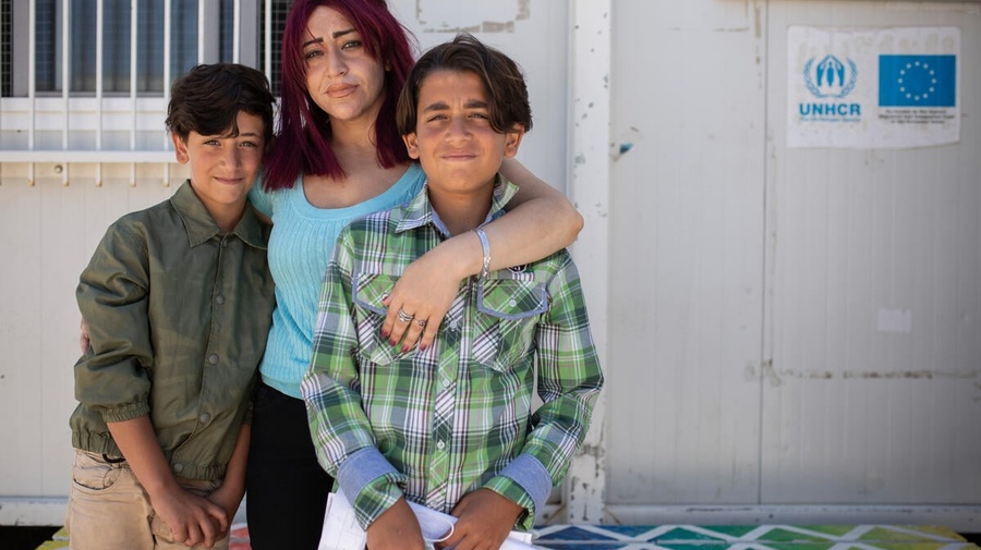 A woman and her two young sons, who are asylum-seekers from Syria, pose for a picture.