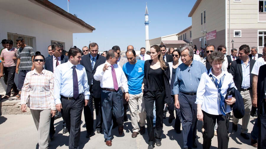 Angelina Jolie (in black) and António Guterres (next to her in blue open neck shirt) tour a camp housing thousands of Syrian refugees in Turkey.
