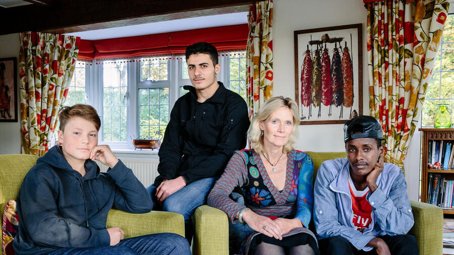 United Kingdom. Ingrid Van Loo Plowman and her youngest son Ross, host three refugees in their home in Epsom, near London: Isak, 18, from Ethiopia, 19-year-old Abdul, from Syria and a 31-year-old engineer from the Middle East who declined to be identified for security reasons. This portrait is part