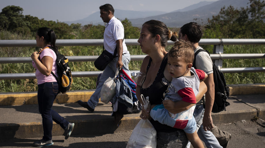A Venezuelan mother holds her child as she crosses the Simon Bolivar Bridge to Colombia, in  January 2019.