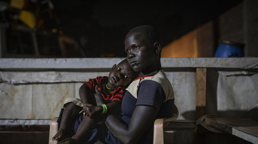 Democratic Republic of Congo. A newly arrived South Sudanese refugees mother holds her baby boy as they wait to receive a meal and accommodation at the transit centre in Aru