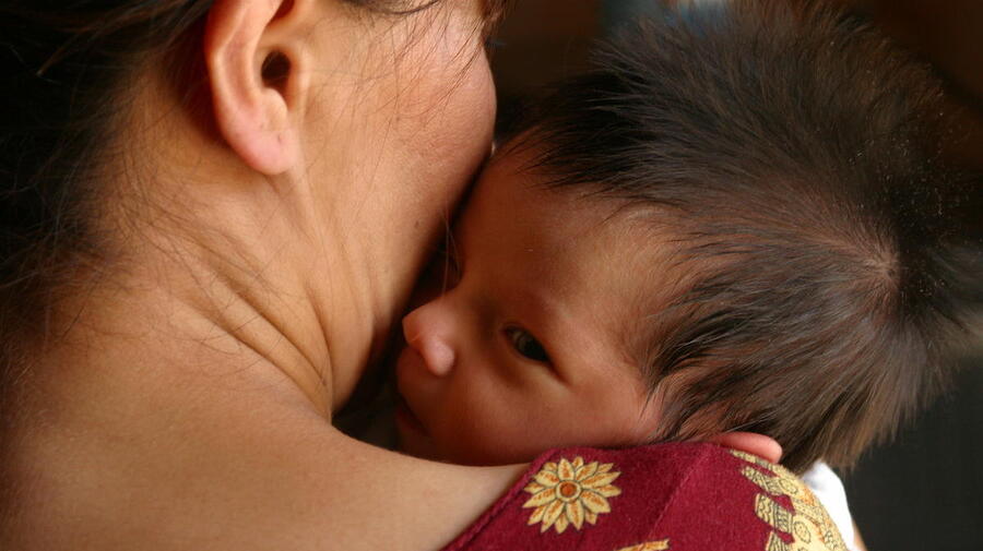 Turkmenistan. A woman holds her infant