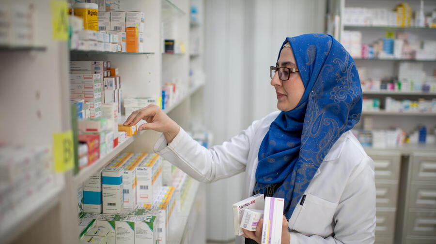 UNHCR UN Refugee Agency Public Health - Salam Al-Hariri, 26, is a Syrian refugee, mother and trainee pharmacist in Amman. She's standing in front of a shelf, sorting medical packages. 