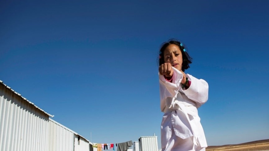 A young girl practices karate moves.