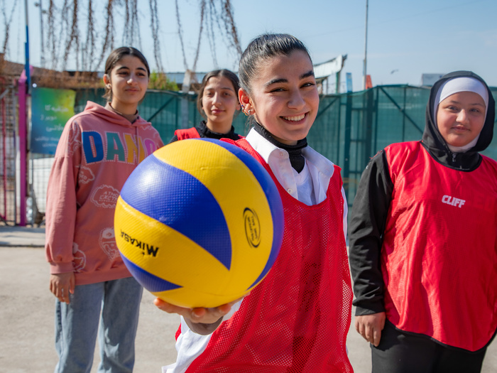 Syrian refugee girl holds a basketball